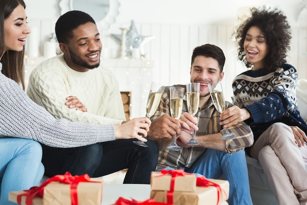 Dwie młode pary świętują Nowy Rok i wznoszą toast szampanem w domu