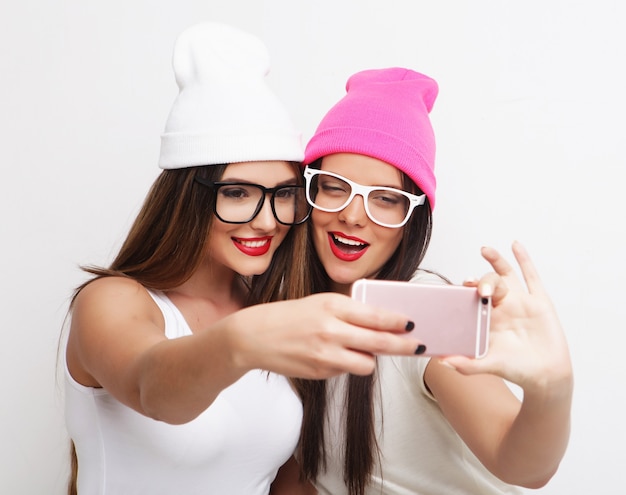 Dwie Nastoletnie Dziewczyny Przyjaciółki W Stroju Hipster Zrobić Selfie Na Telefonie.