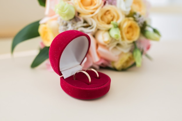 Dwie obrączki w czerwonym pudełku i wiosennych kwiatach. Koncepcja ślubu.