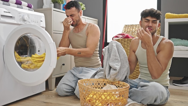 Dwie pary mężczyzn pachnące brudnymi ubraniami w pralni