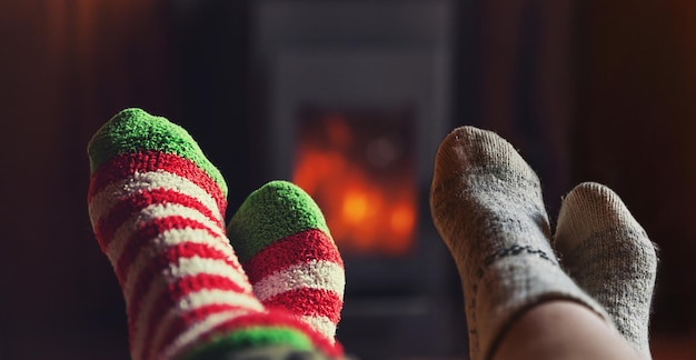 Zdjęcie dwie pary stóp nogi w zimowych wełnianych skarpetach na tle kominka para rodzina siedzi w domu na wygranej...