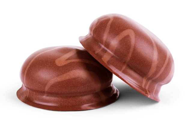 Dwie pianki pokryte czekoladą, jedna odgryziona, na białym tle