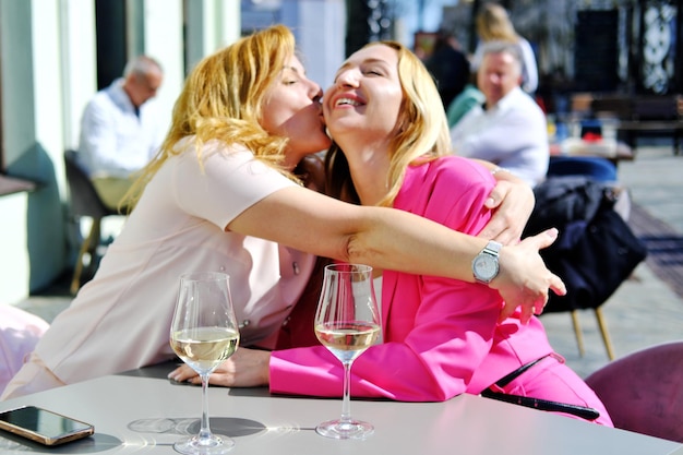Dwie piękne dorosłe blondynki spotkały się przy stoliku w kawiarni i przytulały się, kiedy się spotykają