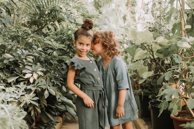 Dwie Piękne Dziewczynki Różnych Narodowości Spacerują Po Ogrodzie Botanicznym I Dochowują Tajemnic