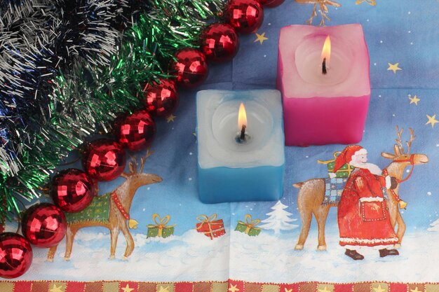 Dwie płonące świece z dekoracją noworoczną