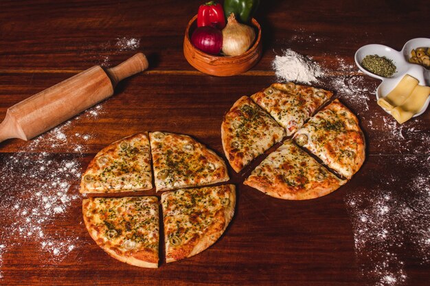 Dwie pokrojone pizze mozzarella na drewnianym stole.