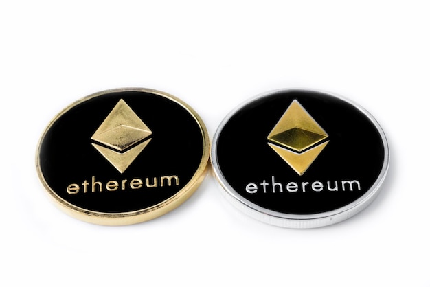 Zdjęcie dwie prawdziwe monety srebrnej i złotej kryptowaluty ethereum izolowane na białym tle