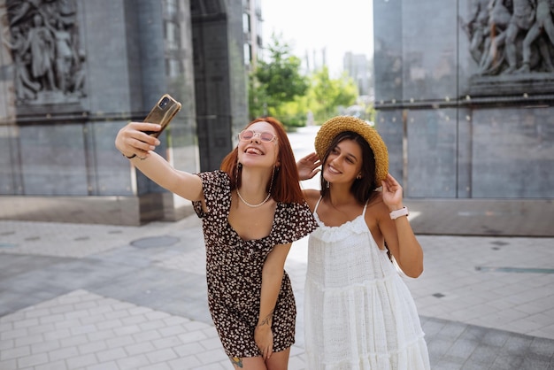 Dwie radosne dziewczyny robiące sobie selfie na ulicy miasta
