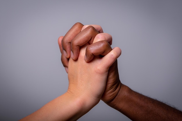Dwie ręce, jedna biała i jedna czarna, uścisk Pojęcie wieloetniczności i rasizmu