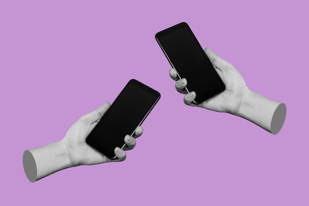 Dwie ręce trzymające telefony komórkowe z czarnymi ekranami pustą przestrzeń do kopiowania na liliowym tle