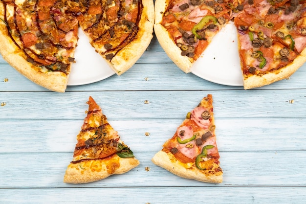 Dwie różne pyszne duże pizze na niebieskim tle drewnianych.