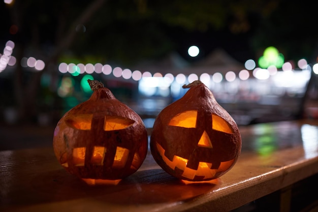 Dwie rzeźbione dynie podczas obchodów Halloween nocą w mieście