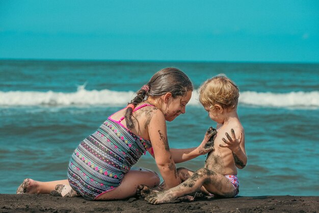 Zdjęcie dwie siostry bawiące się na plaży.