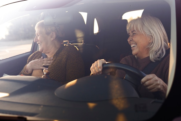 Dwie starsze kobiety w samochodzie jeżdżą i jadą na przygodę na łonie natury