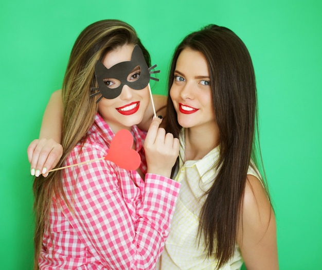 Dwie stylowe seksowne hipsterskie dziewczyny najlepsi przyjaciele gotowi na imprezę, na zielonej powierzchni