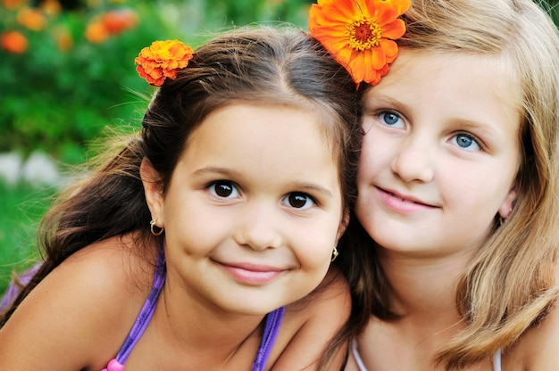 Zdjęcie dwie szczęśliwe młode dziewczyny, dzieci bawią się na świeżym powietrzu w przyrodzie