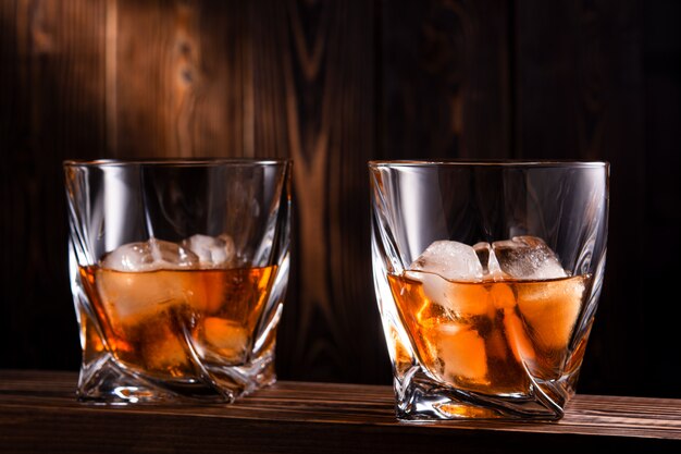 Dwie szklanki alkoholu na drewnianej ścianie