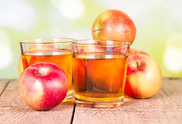 Dwie szklanki soku jabłkowego na drewnianej powierzchni