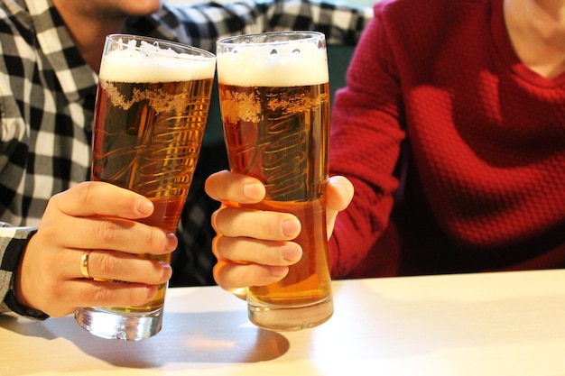 dwie szklanki spienionego jasnego piwa w barze, piwo jęczmienne filtrowane i niefiltrowane, bar sportowy, piwo
