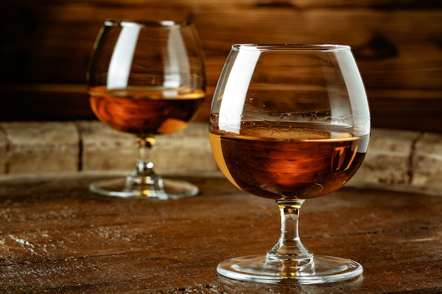 Dwie szklanki whisky na drewnianym stole w barze