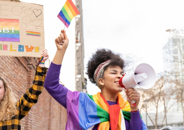 Dwie Wieloetniczne Kobiety świętujące Dumę Gejów Noszące Tęczową Flagę, Symbol Ruchu Społecznego Lgbt