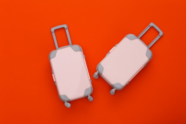 Dwie zabawki bagaż podróżny na pomarańczowo. Planowanie podróży