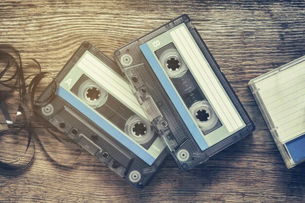 Zdjęcie dwie zabytkowe kasety magnetofonowe na drewnianym tle