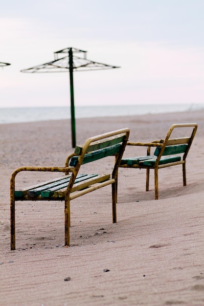 Zdjęcie dwie zardzewiałe ławki na plaży