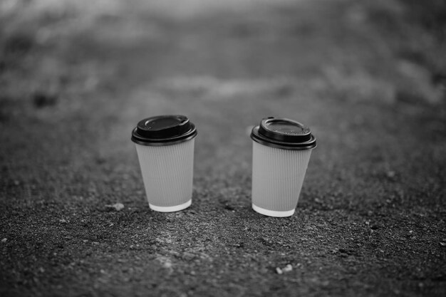 Dwie żółte Papierowe Kubki Kawy Na Ciemnym Tle Czarno-białe Zdjęcie
