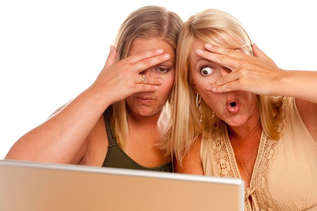 Dwie zszokowane kobiety używające laptopa