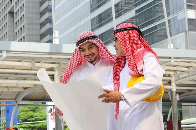 Zdjęcie dwóch arabskich inżynierów dyskusji razem w nowoczesnym mieście