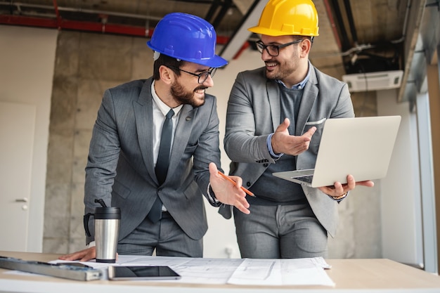 Dwóch architektów zajmujących się budownictwem w procesie budowlanym rozmawia i przeprowadza burzę mózgów na temat innowacji w swoim projekcie.