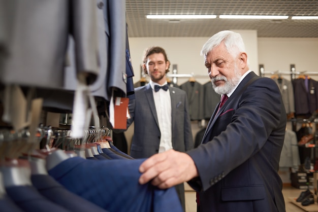 Dwóch atrakcyjnych mężczyzn kupujących kostiumy w męskim sklepie.