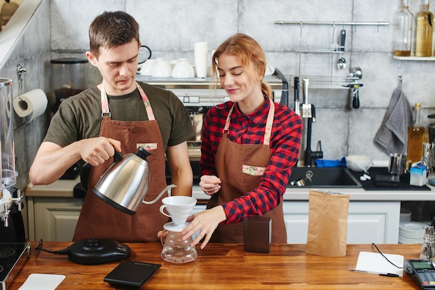 Dwóch baristów. Facet i dziewczyna pracują przy kawie