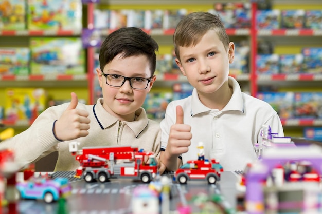 Dwóch chłopców bawi się razem kolorowymi plastikowymi klockami w szkole centrum gier