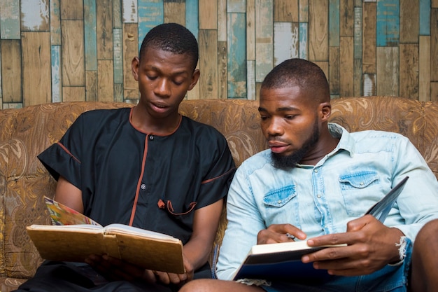 Dwóch czarnych afrykańskich studentów poważnie studiujących swoją pracę szkolną przed egzaminem.