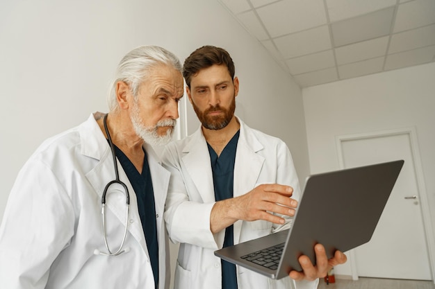 Zdjęcie dwóch kolegów lekarzy w mundurach omawiających diagnozę pacjenta stoi w klinice medycyny