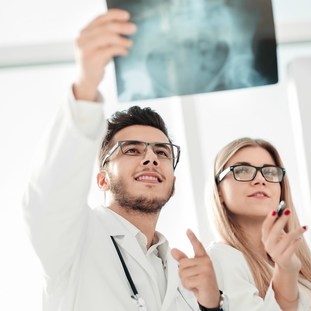 Dwóch lekarzy ortopedów patrząc na zdjęcie rentgenowskie pacjenta
