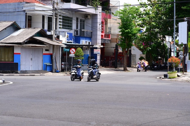 Dwóch ludzi na skuterach jedzie ulicą.
