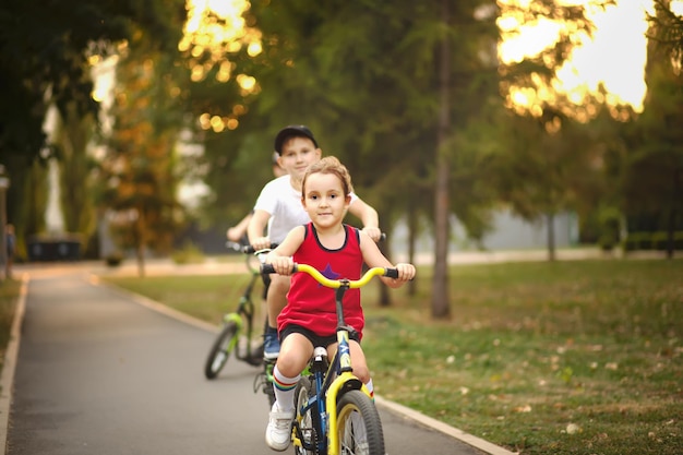 Dwóch małych rowerzystów chłopiec i dziewczynka jeżdżą na rowerach i cieszą się zabawą Dziecko na świeżym powietrzu sport letnie aktywności