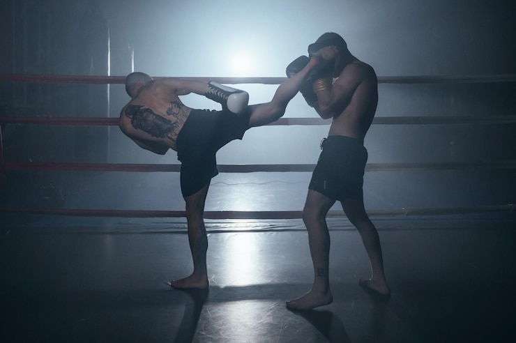 Zdjęcie dwóch mięśniowych mężczyzn bez koszuli walczących w kickboksu na ringu