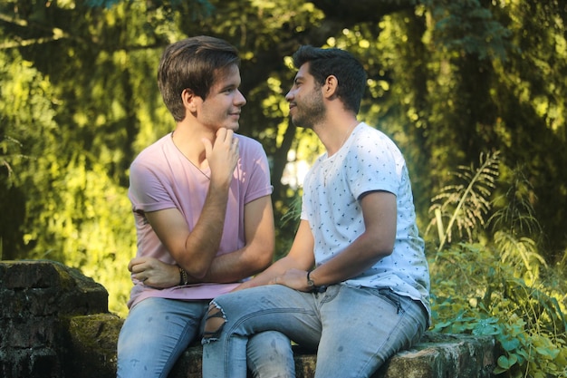 Dwóch młodych gejów całuje się w parku przyrody