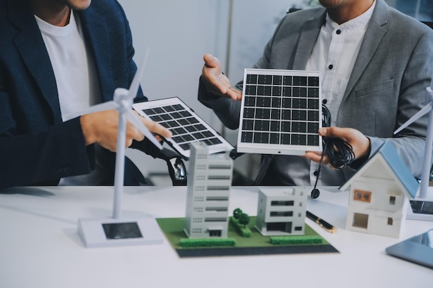 Dwóch młodych inżynierów posiadających doświadczenie w instalacji ogniw słonecznych spotkało się i omówiło pracę w zakresie planowania instalacji paneli fotowoltaicznych na dachu pomieszczenia biurowego wraz z planem budowy fabryki.