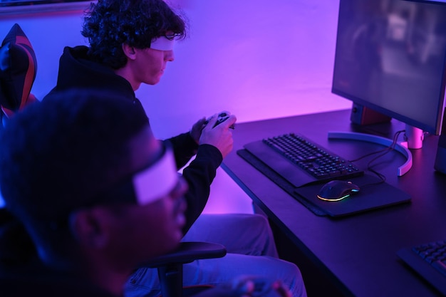 Dwóch młodych ludzi używa okularów wirtualnej rzeczywistości do grania w swoje ulubione gry wideo online Streaming gier Concept Technology