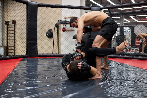 Dwóch profesjonalnych bokserów w dynamicznej akcji bokserskiej na ringu na siłowni. Bokser uderzył przeciwnika, wykonując różne sztuczki walki, koncepcja sportowa