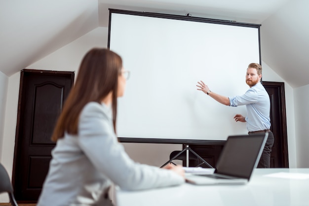 Dwóch przedsiębiorców pracuje nad prezentacją w sali konferencyjnej.