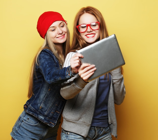 Dwóch przyjaciół dziewczyny hipster biorąc selfie z cyfrowego tabletu