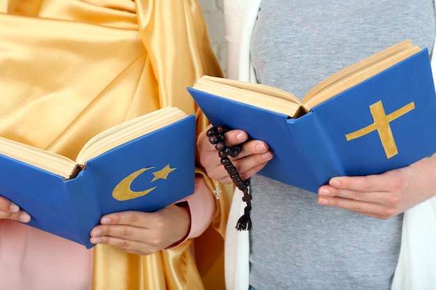 Dwóch przyjaciół trzymających książki z symbolami religii