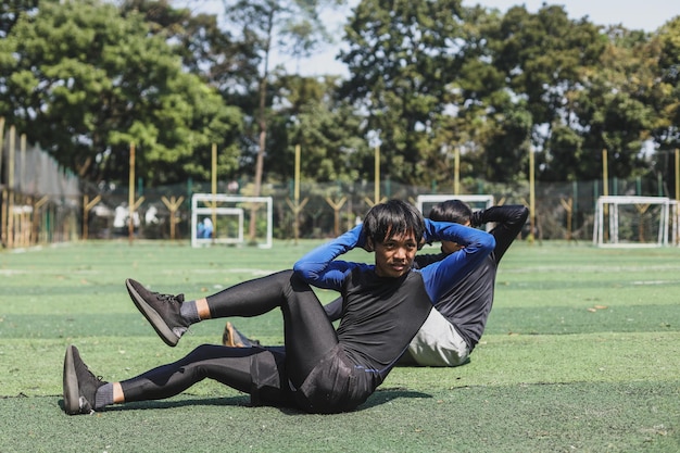 Dwóch sportowców ćwiczących, by utrzymać silne mięśnie dla opieki zdrowotnej w parku sportowym.