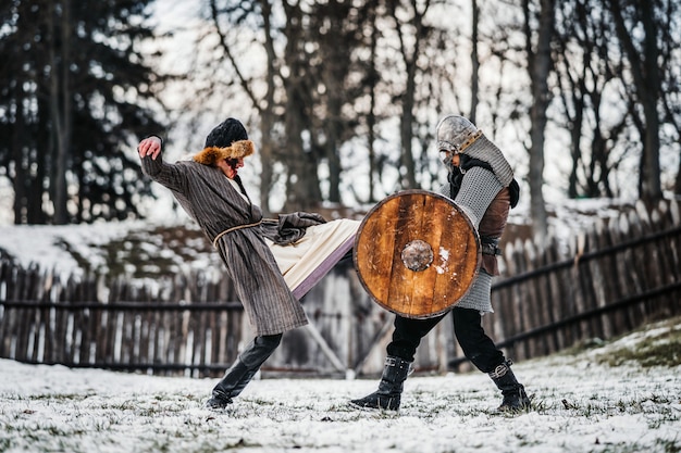 Dwóch Starożytnych Wojowników W Zbroi Z Bronią Walczącą Z Mieczami Na śniegu